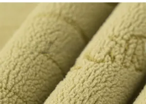 Dettaglio macro del tessuto pile spesso giallo senape con morbida trama isolante