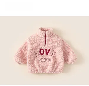 Detail of pink sherpa fleece sweatshirt with pineapple texture and LOVE BOBO patch