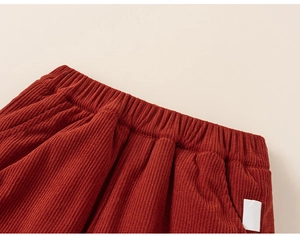 Detail of caramel corduroy kids pants showing elastic waistband and fine stitching