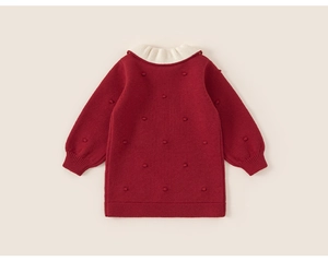 Close-up of girls' red knit dress featuring white lace collar and textured bobble details