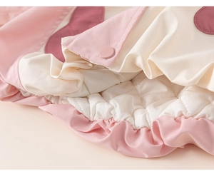 Close-up of pink children's winter jacket with snap buttons and diamond quilted lining