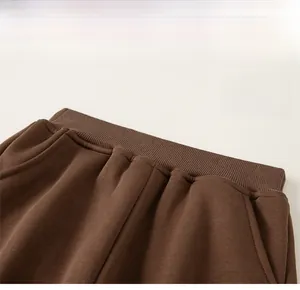 Detailed macro view of elastic waistband and side pocket on brown kids winter joggers