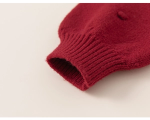 Detailed macro view of the soft ribbed knit cuff on a red girl sweater dress