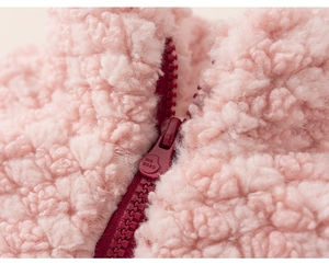 Macro detail of high-quality zipper and soft pink sherpa fleece texture on warm kids jacket