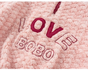 Detail of pink fleece fabric with red zipper and Love Bobo 3D embroidery texture