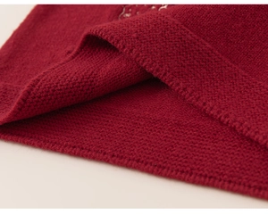 Detailed macro view showing the soft texture and dense knit of the red girl sweater dress