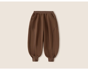 Detailed close-up of dark brown kids jogger pants showing arched seams and elastic cuffs