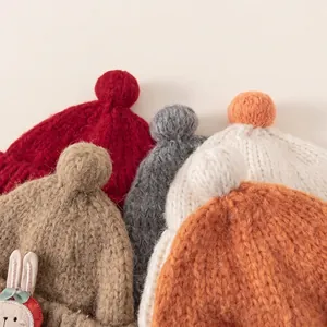 Thick knit baby beanie with faux fur pompom and rabbit patch in various warm autumn colors