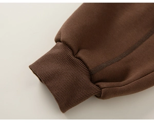 Detail of ribbed cuffs on dark brown thick cotton fleece trousers for boys