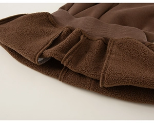 Close-up of thick sherpa fleece lining and ribbed cuff on brown winter pants