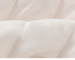 Close-up of quilted cream toddler jacket fabric showing soft texture and stitching