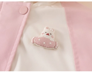 Close-up of baby girl hoodie with rabbit embroidery and decorative pearl buttons