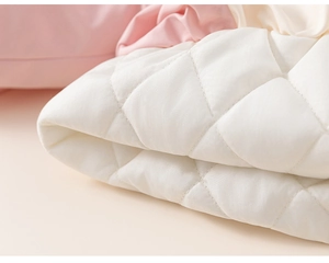 Close-up detail of white diamond quilted fabric texture for kid winter hoodie coat