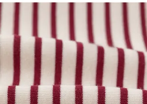 Close-up of red and white striped knitted fabric showing soft cotton texture and elasticity
