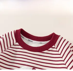 Close-up of the ribbed crew neck and red striped cotton fabric on a child sweater