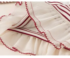 Detail of red and white striped knit fabric with layered white chiffon hem and wavy edges