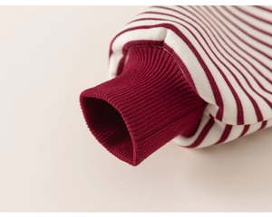 Close-up of red and white striped knit fabric with elastic ribbed cuff detail