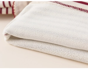Detailed macro view of the warm white fleece lining and red striped knit fabric