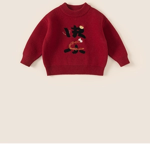 Close-up of red knit sweater featuring festive Chinese characters and golden ingot details