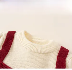 Detail of the cream rib-knit neckline and red decorative shoulder straps on a girl dress