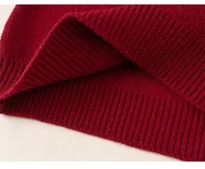 Close-up of red festive knitted sweater showing elastic ribbed hem and thick texture