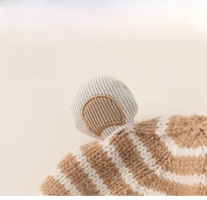 Detail view of knitted baby hat with cute 3D animal ears and brown striped texture