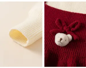 Detailed close-up of ribbed cuffs and a cute 3D plush bear on a red knitted girls dress