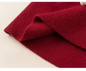 Detail of red knitted girl's dress showing high-quality vertical rib texture and hemline