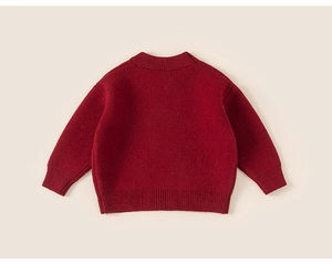 Close-up of red children's knit sweater showing warm ribbed cuffs and high-quality texture
