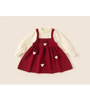 Detail of red knit dress with cream long sleeves and cute teddy bear bow decorations
