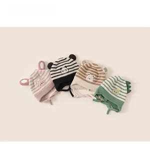 Detail of baby animal hats with striped knit texture and cute embroidered ear flaps