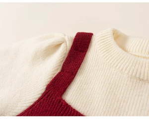 Close-up detail of knitted sweater neckline and shoulder with red contrast stitching