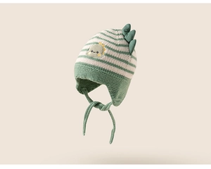 Detailed knit texture of green striped baby dinosaur hat with earflaps and embroidery