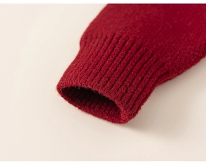 Detail of red knitted sweater ribbed cuffs showing fine texture and warm material