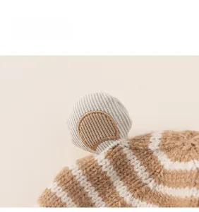 Close-up of the knitted ear detail and brown striped texture on the baby winter hat