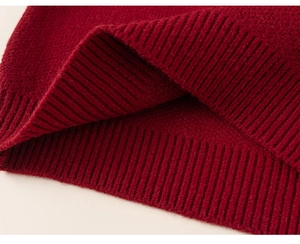 Detailed macro view of deep red knitted fabric showing rib-knit texture and elastic cuffs