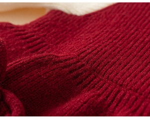 Detailed macro view of the thick dark red knit fabric with vertical ribbed texture
