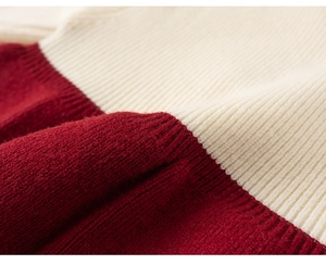 Close-up of red and cream ribbed knit fabric showing the soft texture and stitch detail