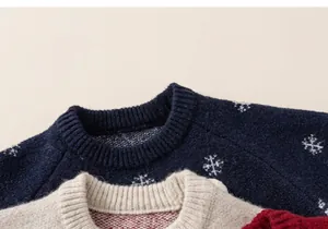 Detailed close-up of knit texture and snowflake pattern on children sweaters