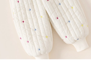 Détail du pantalon matelassé pour enfant avec broderies cœurs et poignets côtelés