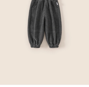 Détail du pantalon rayé pour enfant montrant la texture grise et la poche latérale