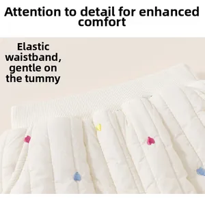 Détail de la taille élastique et broderies de cœurs colorés sur pantalon matelassé blanc