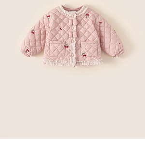 Détail de la veste matelassée rose avec broderie cerise et nœuds décoratifs doux