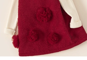 Detail of red textured knit girls' dress with 3D mesh flowers and ribbed white sleeves