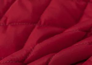Detailed close-up of the red diamond-quilted fabric texture on this children's winter dress