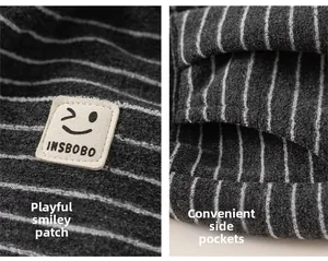 Détail d'un pantalon rayé gris avec écusson en cuir clin d'œil et poches latérales pratiques