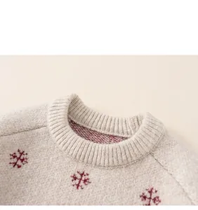 Close-up of kids beige round neck sweater with red snowflake jacquard knit detail