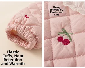 Détails d'une veste matelassée rose pour enfant avec broderie cerise et poignets élastiques