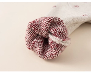 Close-up of thick knitted sleeve cuffs with soft off-white wool and red checkered lining