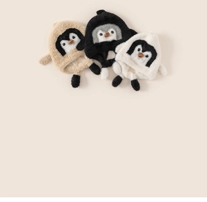 Detailed view of knitted plush toddler beanies with cute penguin faces and ear flaps